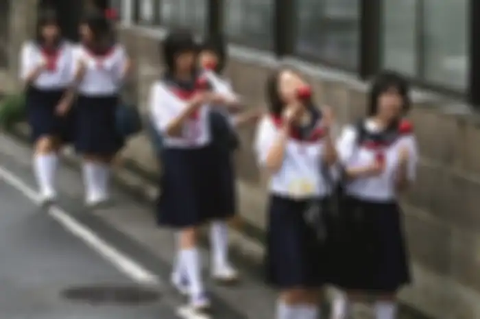 Japanese schoolgirls walking and eating.