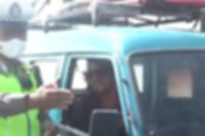 Polisi saat menilang warga negara Amerika, LBM (36), yang mengemudikan angkot di simpang Jalan Sunset Road - Jalan Imam Bonjol, Denpasar, Bali, pada Senin (12/6/2023). 