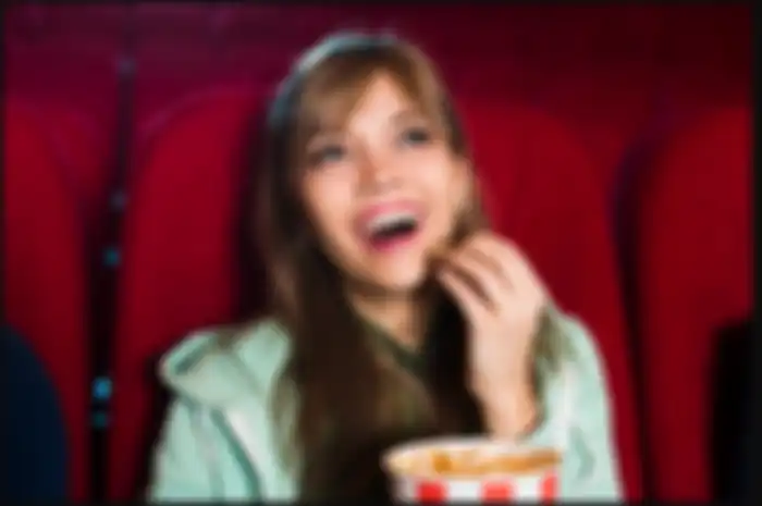 Ilustrasi makan popcorn saat nonton di bioskop