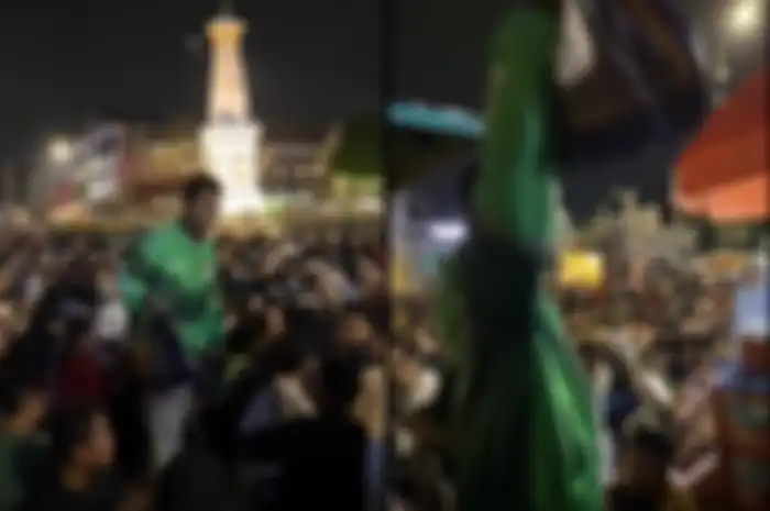Driver ojol mengantar pesanan  untuk customer di antara lautan manusia saat malam tahun baru di Tugu Jogja.
