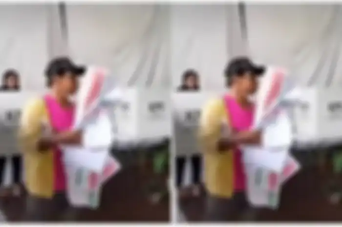 Pria ini kesulitan melipat kembali surat suara usai dicoblos.