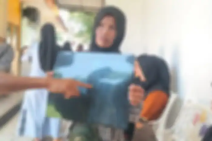 Ibu dan paman Bela Cintia, korban penembakan, menunjukkan hasil rontgen peluru di perut saat menjalani kontrol di RSUD Pariaman.