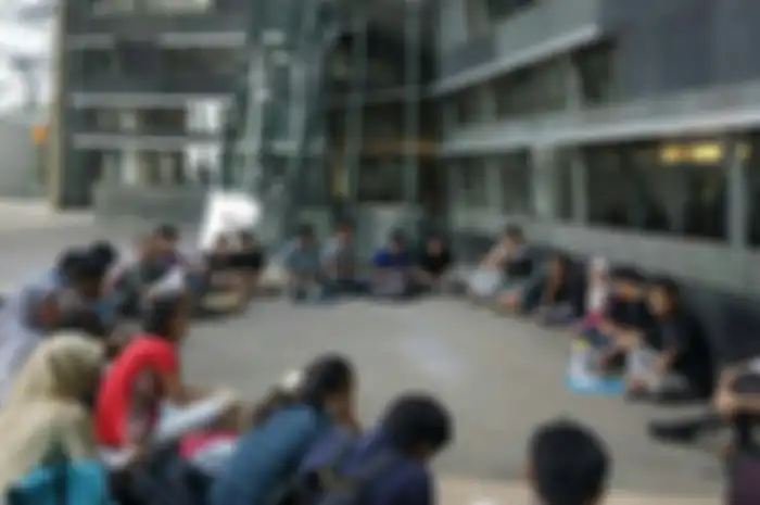 Beberapa mahasiswa terlihat sedang melakukan diskusi terbuka di lingkungan kampus mereka.