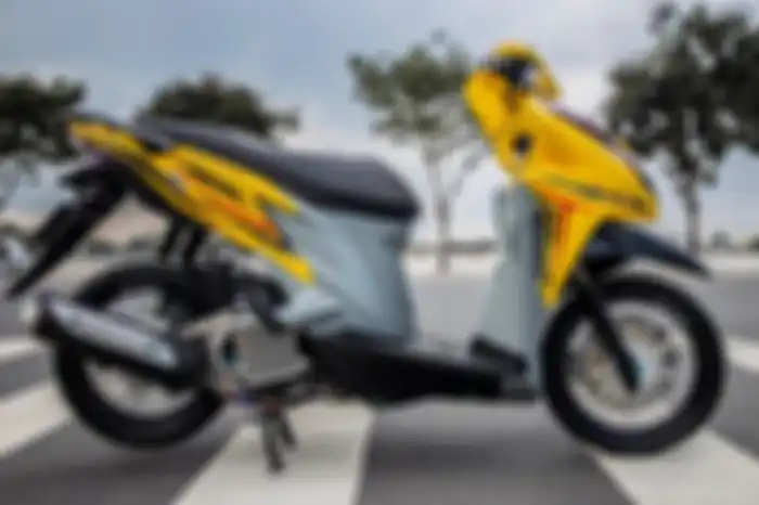 Honda Vario 125 dibalur warna kuning dan abu-abu.