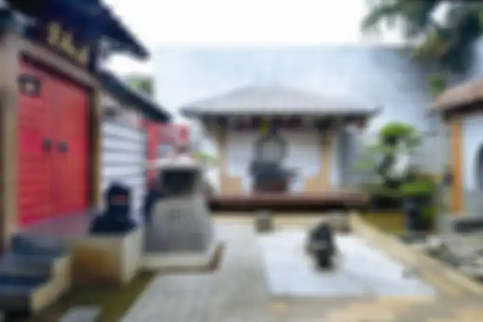 Taman kering di bagian belakang rumah, bergaya Jepang dominan elemen keras.