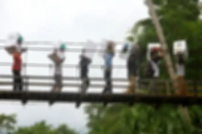  Petugas melintasi Jembatan Gantung.