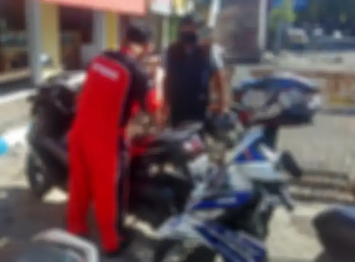 Mekanik Yamaha tengah memperbaiki motor konsumen.
