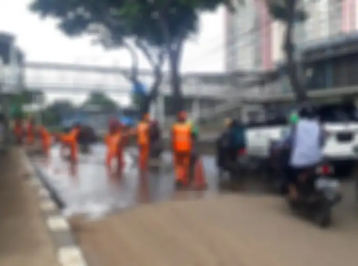 Proses pembersihan jalan dari sisa tanah