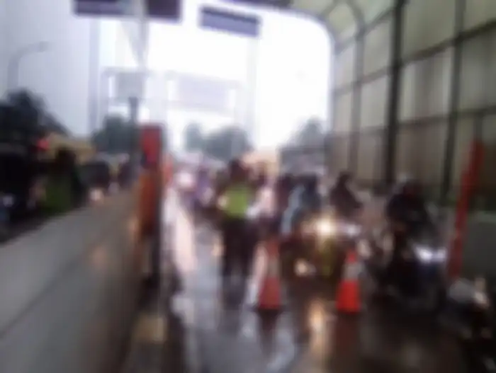 Pemotor terobos tol Rawa Buaya, Cengkareng Jakbar akibat banjir yang melanda sebagian jalanan pada Selasa (25/2/2020).