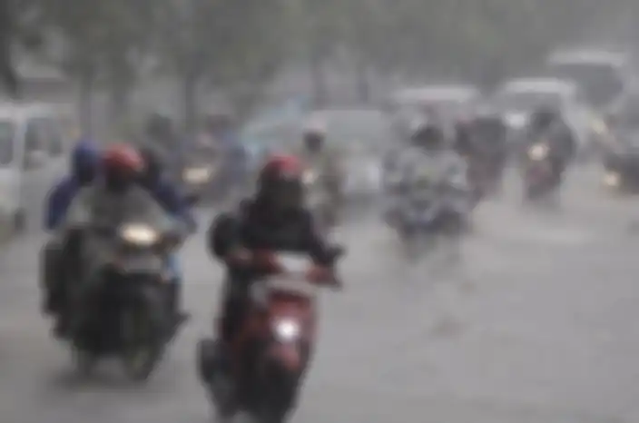Ilustrasi berkendara motor saat hujan.