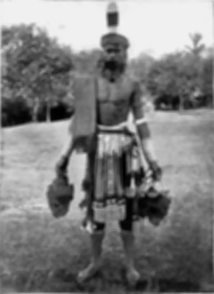 Seorang Dayak pemburu kepala di Borneo sekitar 1900-1912. Setiap satu atau dua tahun sekali the Dayak Iban menyelenggarakan adat Gawai Autu untuk menghormati arwah leluhur yang dipercaya berada disekeliling kepala yang tergantung di rumah mereka. Dalam upacara adat itu mereka berharap mendapatkan be