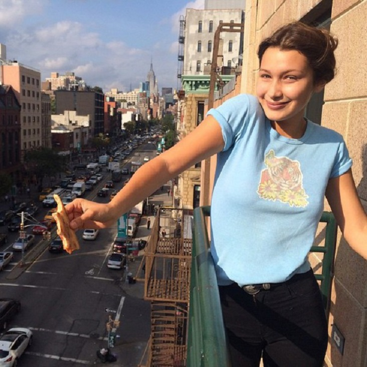Bella Hadid memakai rolled sleeve tee dan jeans