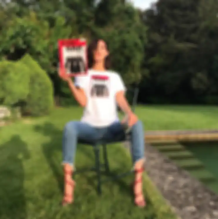 Bella Hadid memakai printed tee, jeans, dan wrapped heels