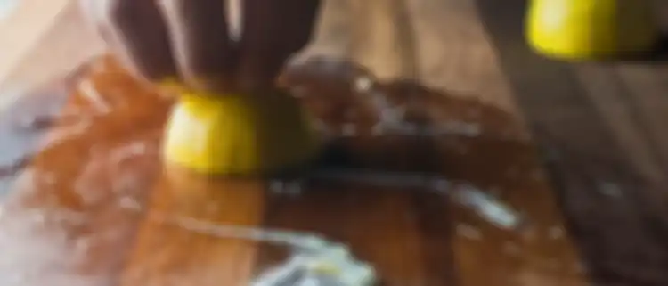 Taburkan garam, lalu gosok dengan setengah lemon untuk membersihkan talenan kayu dari bau bawang.