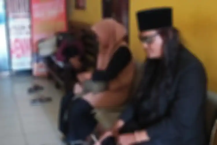 Robi Anjal (38) asal Pontianak, Kalimantan Barat, bersama istri dan anaknya saat menunggu panggilan pemeriksaan polisi di Polres Sampang, Senin (29/7/2019). 