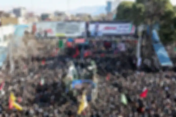 Warga Iran berdatangan di sekeliling mobil yang membawa jenazah Jenderal Qasem Soleimani.