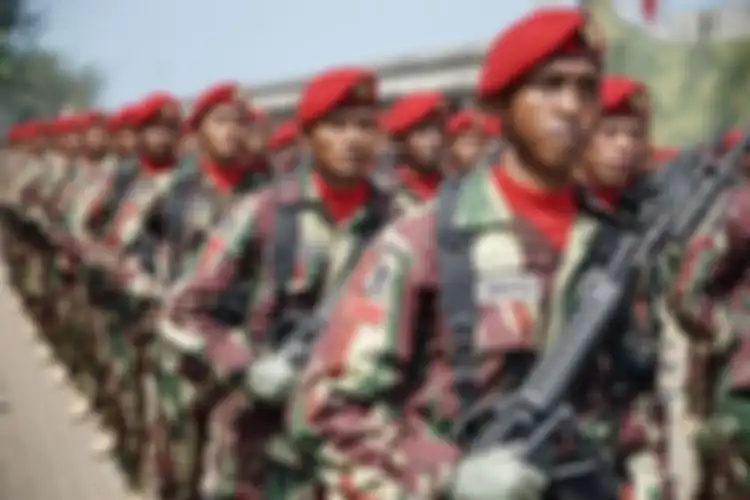 Pasukan Kopassus mengenakan baret berwarna merah dengan lambang Tribuana Chandraca Satya Dharma.