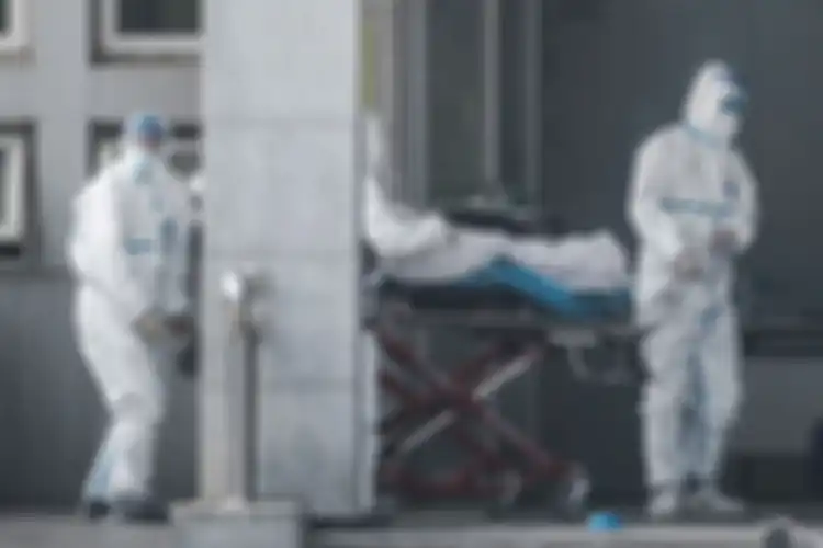 Petugas medis membawa seorang pasien yang diduga terinfeksi virus misterius mirip SARS, ke rumah sakit Jinyintan, di Kota Wuhan, China, Sabtu (18/1/2020).
