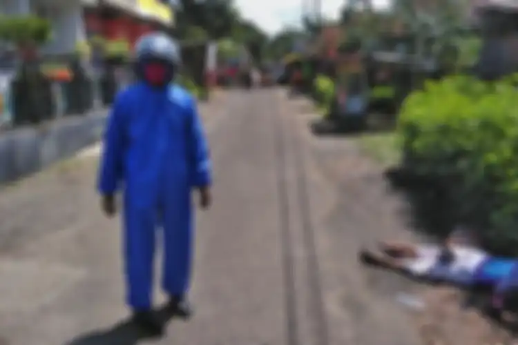 Anggota Polsek Kutasari, Purbalingga, Jawa Tengah membantu evakuasi pemudik wanita yang diturunkan dari travel karena alami sesak nafas di jalan raya Kutasari, Minggu (26/4/2020).