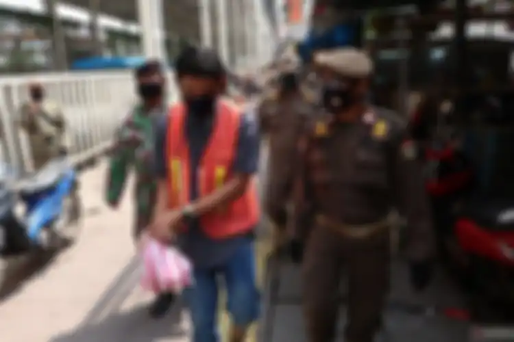 Pelanggar PSBB di Tanah Abang, Jakarta ini diminta mengenakan rompi oranye oleh petugas. 