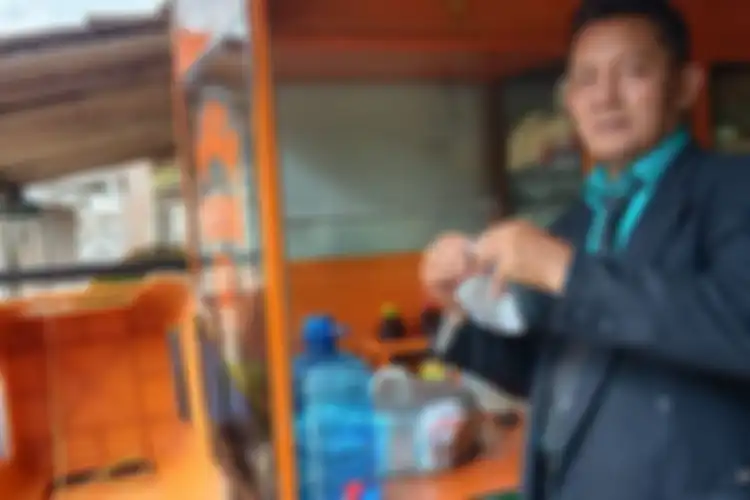 Agus Mujianto menggunakan jas, dasi dan sepati pantofel saat hendak menjual ciloknya di pasar Jenggawah Jember 