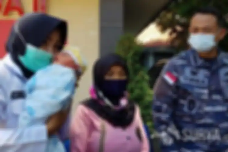 Bidan yang bertugas di Kantor Diskea Koarmada II, Indriyani menggendong bayi laki-laki yang berhasil ditolong dalam persalinan sungsang penuh risiko, Jumat (13/11/2020).