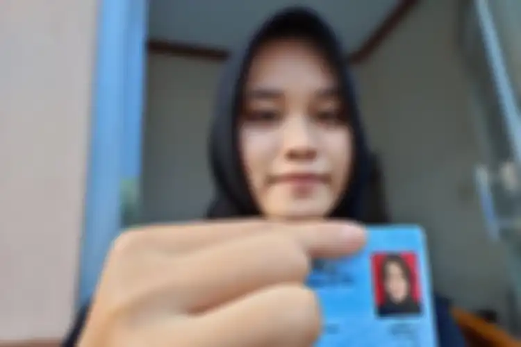 Nadila Suhendar (19), pemilik KTP berfoto tertawa akhirnya memiliki KTP baru dengan foto serius saat ditemui di rumahnya Jalan RE Martadinata, Kota Tasikmalaya, Selasa (15/12/2020).