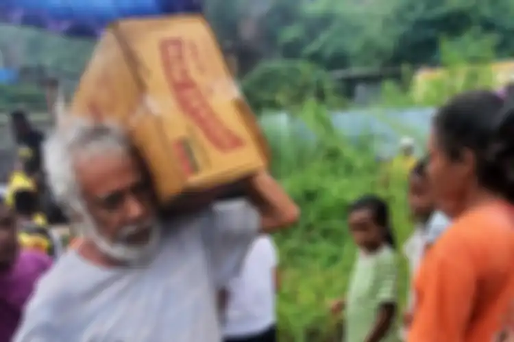 Xanana Gusmao mengangkut kardus saat memberi bantuan penduduk Timor Leste yang menjadi korban banjir.