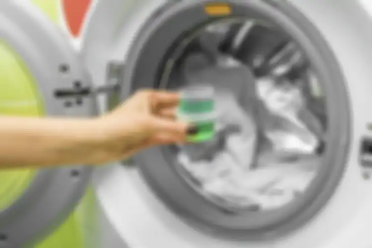 Menambahkan penguat cucian saat mencuci baju putih.