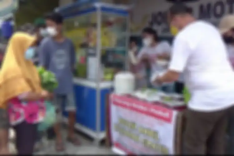 Sejumlah anak muda dari gerakan Warung Medan Peduli memborong dagangan pedagang kecil kemudian dibagikan gratis kepada warga. 