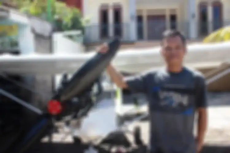 Ujang Elan memegang baling-baling yang terhubung ke mesin motor Yamaha RX-King