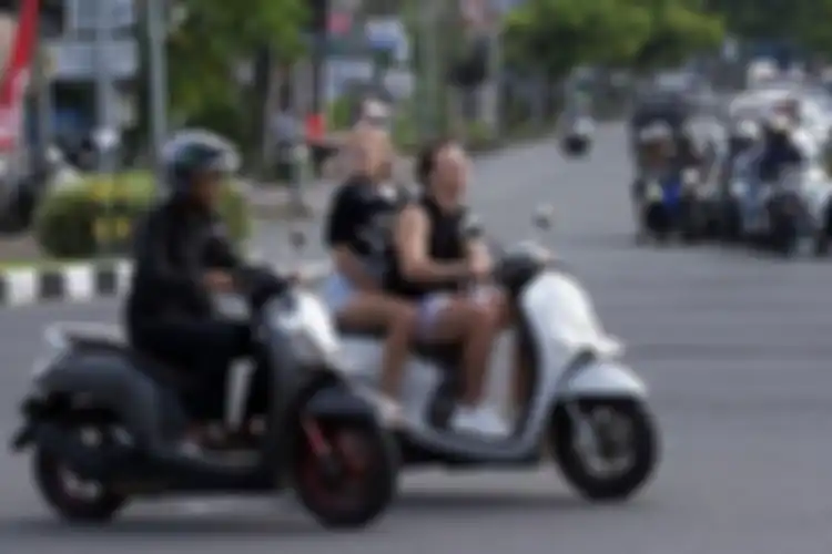 Ilustrasi bule arogan saat mengendarai motor tanpa mengenakan helm.