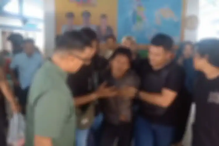 Suami yang membunuh istrinya sendiri di Karimun Kepulauan Riau (Kepri), Iwan (kemeja kotak), saat digiring polisi, Minggu (5/5/2024).