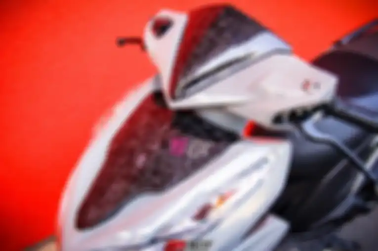 Penggunaan corak karbon pada bagian visor dan sebagian bodi depan Honda Click 125 atau Vario 125.