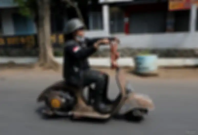 Seorang penggemar ekstrem Vespa mengendarai skuter Vespa setelah mengikuti festival Vespa ekstrem di Semarang, 22 Juli 2018.