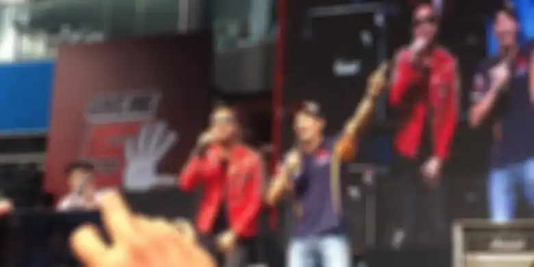 Pebalap Repsol Honda asal Spanyol, Marc Marquez (kanan), bernyanyi dengan vokalis band Nidji dalam a