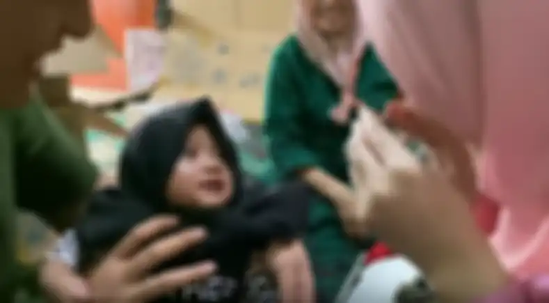 Putri Delina menjahili adiknya dengan mengenakannya kerudung