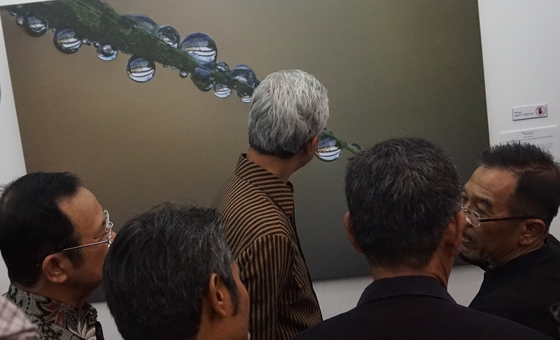 Gubernur Jawa Tengah, Ganjar Pranowo, memberi perhatian pada foto sampah di Bengawan Solo karya Teguh Santosa, seusai pembukaan pameran foto 