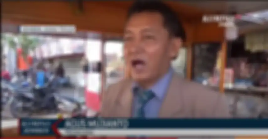 Agus Mujianto menggunakan jas, dasi dan sepati pantofel saat menjual ciloknya di pasar Jenggawah Jember.