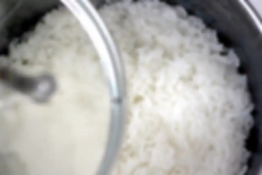 Memasak nasi dengan rice cooker atau magic com.