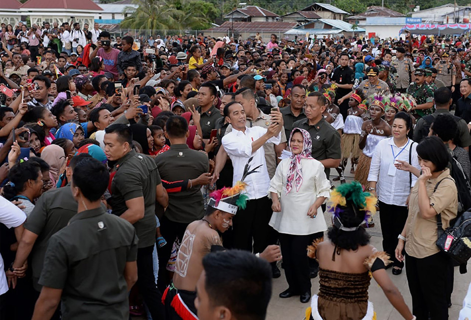 Presiden Joko Widodo atau akrab disapa Jokowi, didampingi Ibu Negara Iriana, berswafoto bersama warga yang menyambut kunjungannya di Kabupaten Kaimana, Papua Barat, Minggu (27/10/2019). Dalam kunjungannya, Jokowi dan Ibu Negara Iriana menikmati senja di Kaimana dengan duduk di tepi anjungan Laut Ara