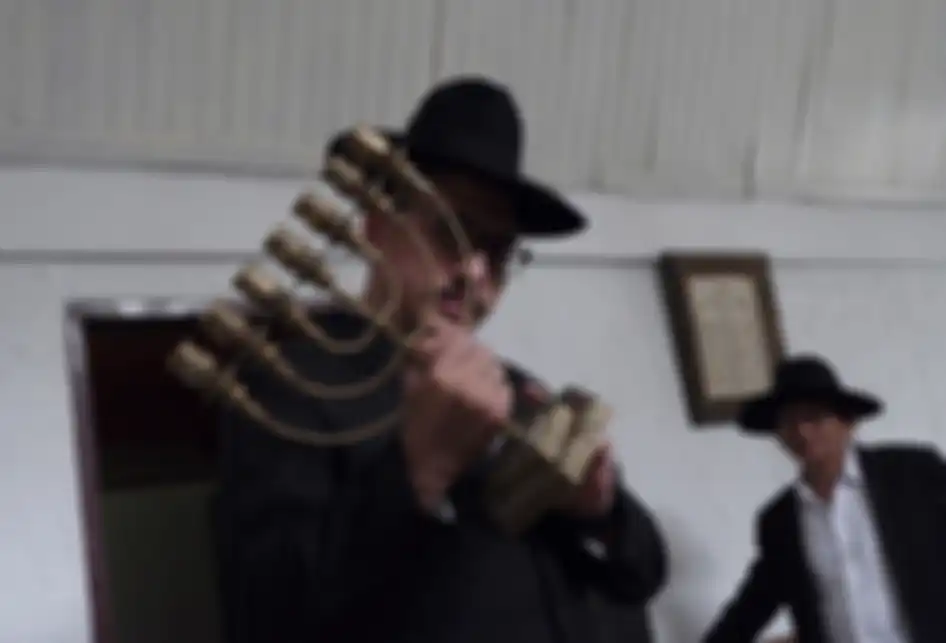 Seorang rabi, Yaakov Baruch (kiri) memegang sebuah menorah (lambang suci bagi umat Yahudi) di sebuah sinagoge di Tondano, Sulawesi Utara, Selasa (4/3/2019). Dari 260 juta penduduk Indonesia, terdapat sekitar 200 orang Yahudi tersisa, yang berjibaku dengan keresahannya menjalani hidup di antara pem