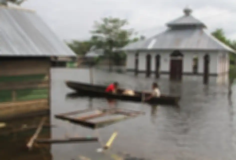 Dua orang anak berada di atas perahu menerobos banjir sejak dua pekan lalu di Desa Laloika, Kecamatan Pondidaha, Konawe, Sulawesi Tenggara, Minggu (9/6/2019). Banjir bandang merendam beberapa kecamatan di Kabupaten Konawe akibat meluapnya Sungai Konaweha disebabkan intensitas hujan tinggi sementara 