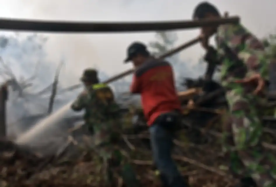 Sejumlah personel TNI Koramil 09 Langgam bersama pemadam kebakaran PT Riau Andalan Pulp and Paper (RAPP) berusaha memadamkan kebakaran lahan gambut di Desa Penarikan Kecamatan Langgam Kabupaten Pelalawan, Riau, Minggu (28/7/2019). Upaya Satgas Karhutla Riau untuk memadamkan kebakaran hutan dan lahan