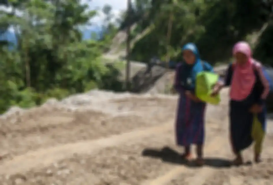 Warga terpaksa berjalan kaki melintasi jalan poros Palu-Kulawi yang longsor di Desa Namo, Kecamatan Kulawi, Kabupaten Sigi, Sulawesi Tengah, Rabu (14/8/2019). Jalan yang longsor pada Selasa (13/8/2019) malam akibat curah hujan yang tinggi itu memutuskan satu-satunya akses keluar masuk di wilayah it