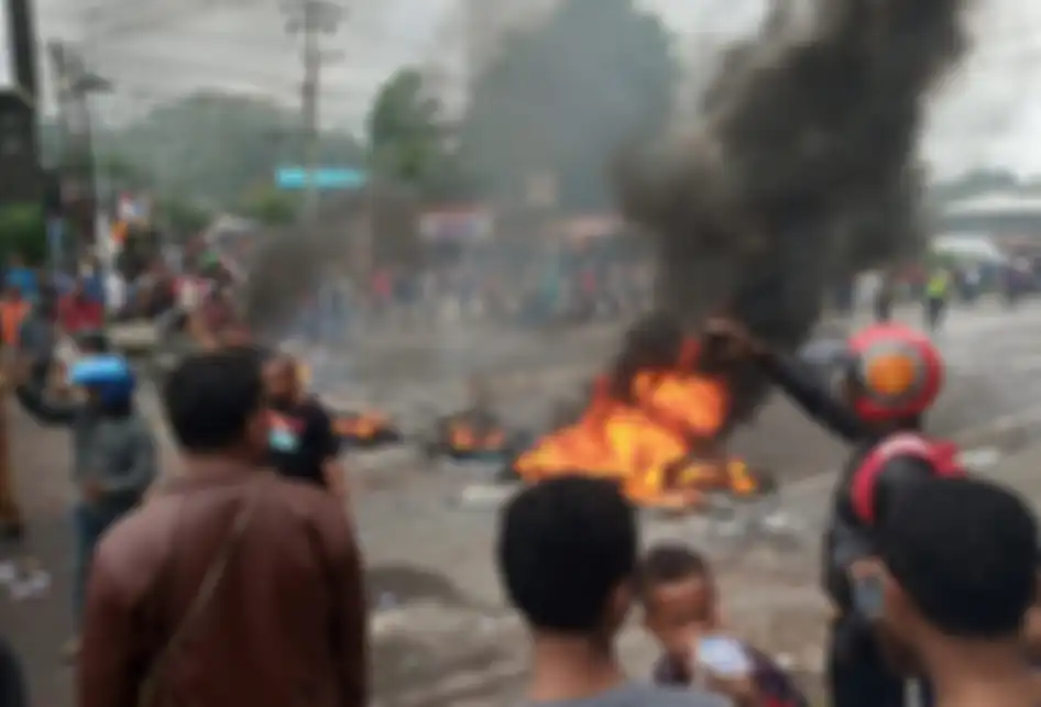 Massa membakar ban saat kerusuhan di pintu masuk Jalan Trikora Wosi Manokwari, Senin (19/8/2019). Aksi ini merupakan buntut dari kemarahan mereka atas peristiwa yang dialami mahasiswa asal Papua di Surabaya, Malang dan Semarang.