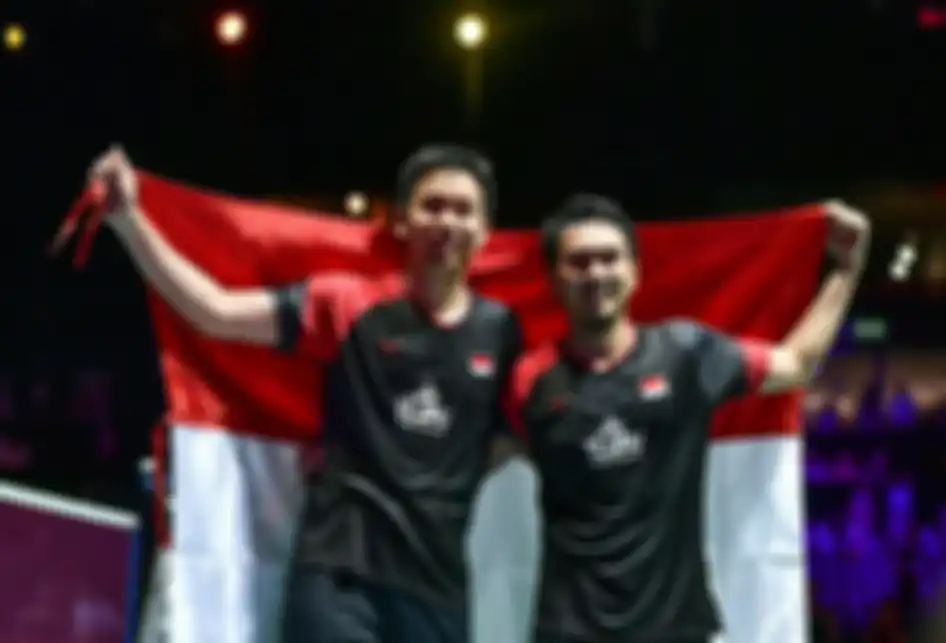 Ganda putra Indonesia Hendra Setiawan (kiri) dan Mohammad Ahsan berpose dengan bendera merah putih usai mengalahkan ganda putra Jepang Takuro Hoki dan Yugo Kobayashi pada babak final Kejuaraan Dunia Bulu Tangkis 2019 di St Jakobshalle, Basel, Swiss, Minggu (25/8/2019). Ahsan/Hendra menjadi juara dunia ganda putra usai menang dengan skor 25-23, 9-21, 21-15.