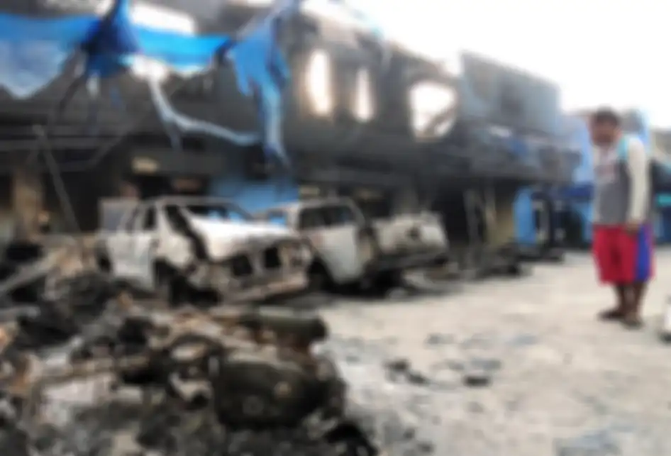 Seorang warga mengamati Kantor Bea Cukai Papua serta sejumlah mobil yang terbakar saat berlangsungnya aksi unjuk rasa di Jayapura, Papua, Jumat (30/8/2019). Sejumlah bangunan dan kendaraan terbakar saat aksi pada (29/8/2019). Sejumlah bangunan dan kendaraan terbakar saat aksi unjuk rasa yang berakhi