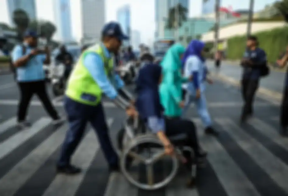 Direktur Utama PT Transportasi Jakarta (TransJakarta) Agung Wicaksono, mendorong calon penumpang penyandang disabilitas ketika melintas di Pelican cross di Halte TransJakarta Bundaran Hotel Indonesia, Jakarta, Rabu (4/9/2019). Kegiatan tersebut sebagai bentuk apresiasi PT TransJakarta terhadap p