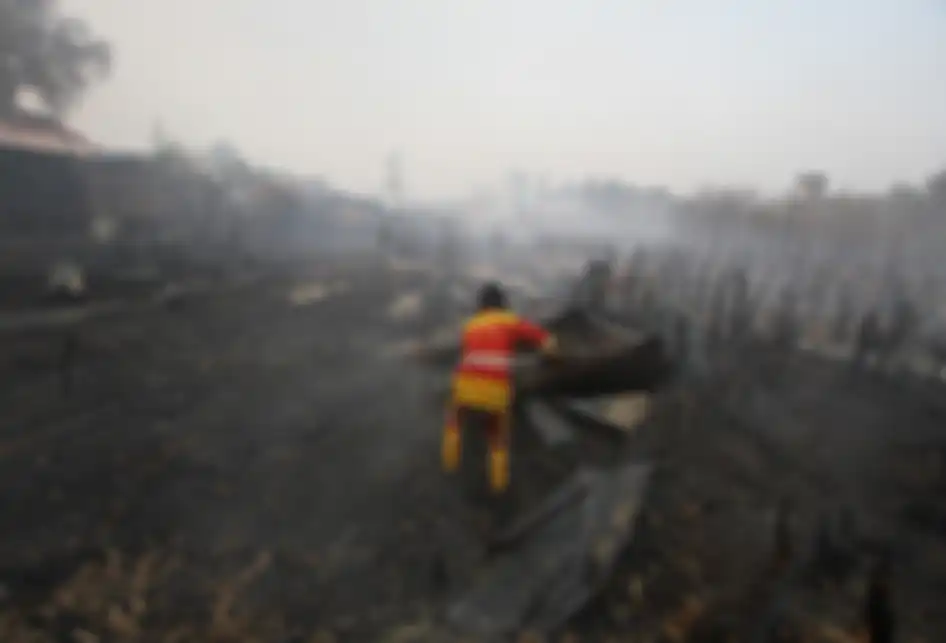 Relawan pemadam kebakaran menyingkirkan atap tempat usaha warga yang hangus terbakar di desa Pengayuan, Banjarbaru, Kalimantan Selatan, Sabtu (14/9/2019). Kebakaran lahan gambut di kawasan tersebut mengakibatkan satu tempat usaha warga dan sebagian dinding rumah warga ikut terbakar.